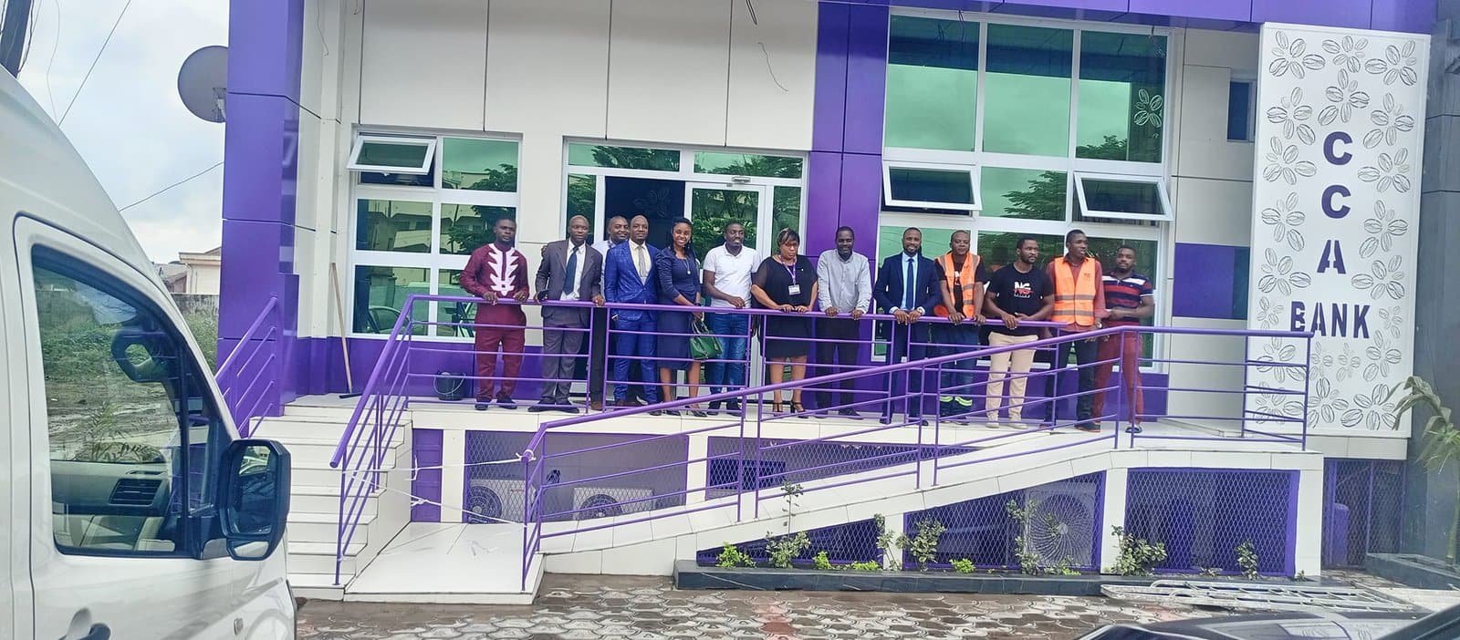 L’équipe NG Design et son client devant la façade violet et blanc de l’agence CCA Bank livrée