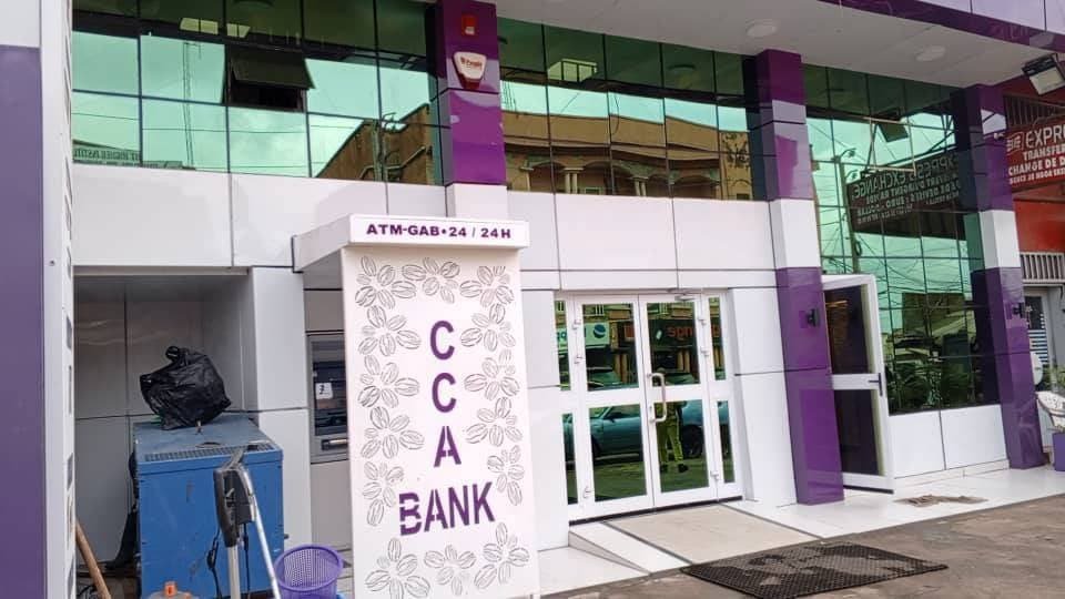 Entrée de l’agence CCA Bank avec le totem au logo et le guichet automatique ouvert 24 h/24