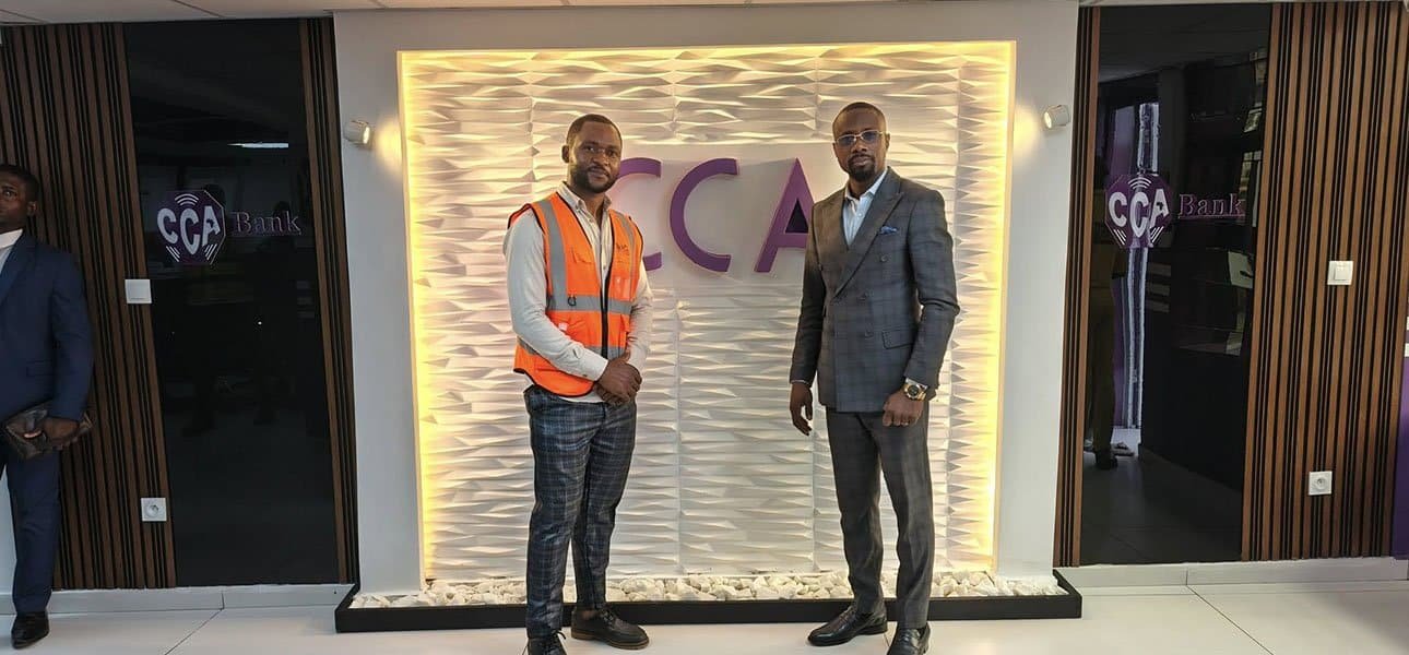 Remise des clés devant le mur au logo CCA, un membre de l’équipe en gilet de chantier