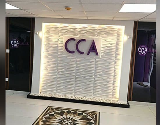 Hall d’agence rénové par NG Design : mur rétroéclairé au logo CCA et lames bois
